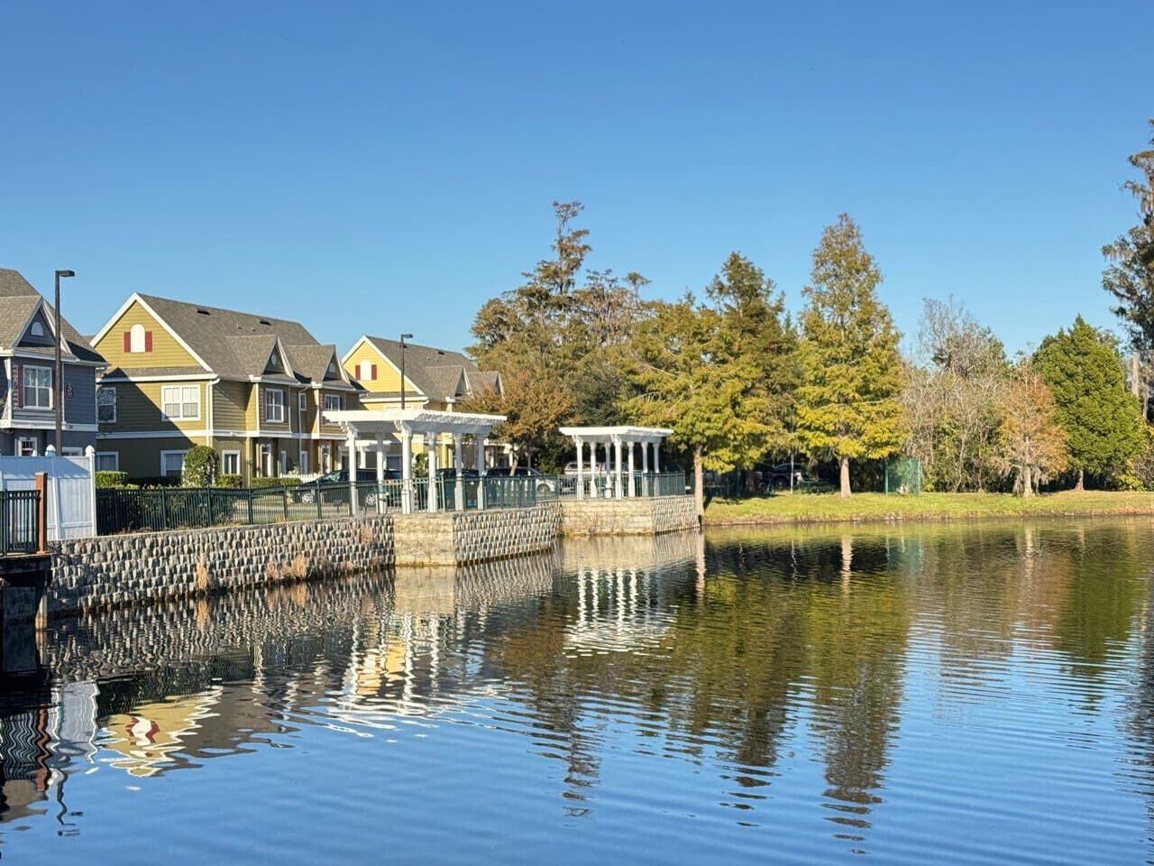 Une propriété située au bord de l’eau, avec une rangée de maisons, un quai et un kiosque.