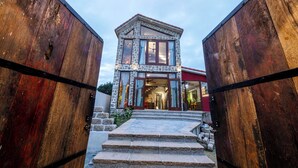 Un edificio de dos pisos de piedra con fachada de piedra y tejado rojo.