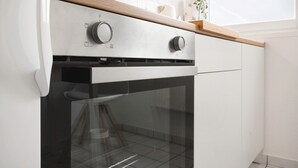 A kitchen with a stainless steel range hood, a wooden countertop, and a white tiled backsplash. - Apartment 'Cozy Mozy - Gemütlichkeit In Bremen' with Wi-Fi (Bremen)