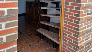 A staircase with a wooden handrail and black balusters, leading to a landing with a wooden cabinet and a framed picture. - Apartment 'Heuboden, 80qm' with Shared Terrace, Shared Garden and Wi-Fi (Werdum)