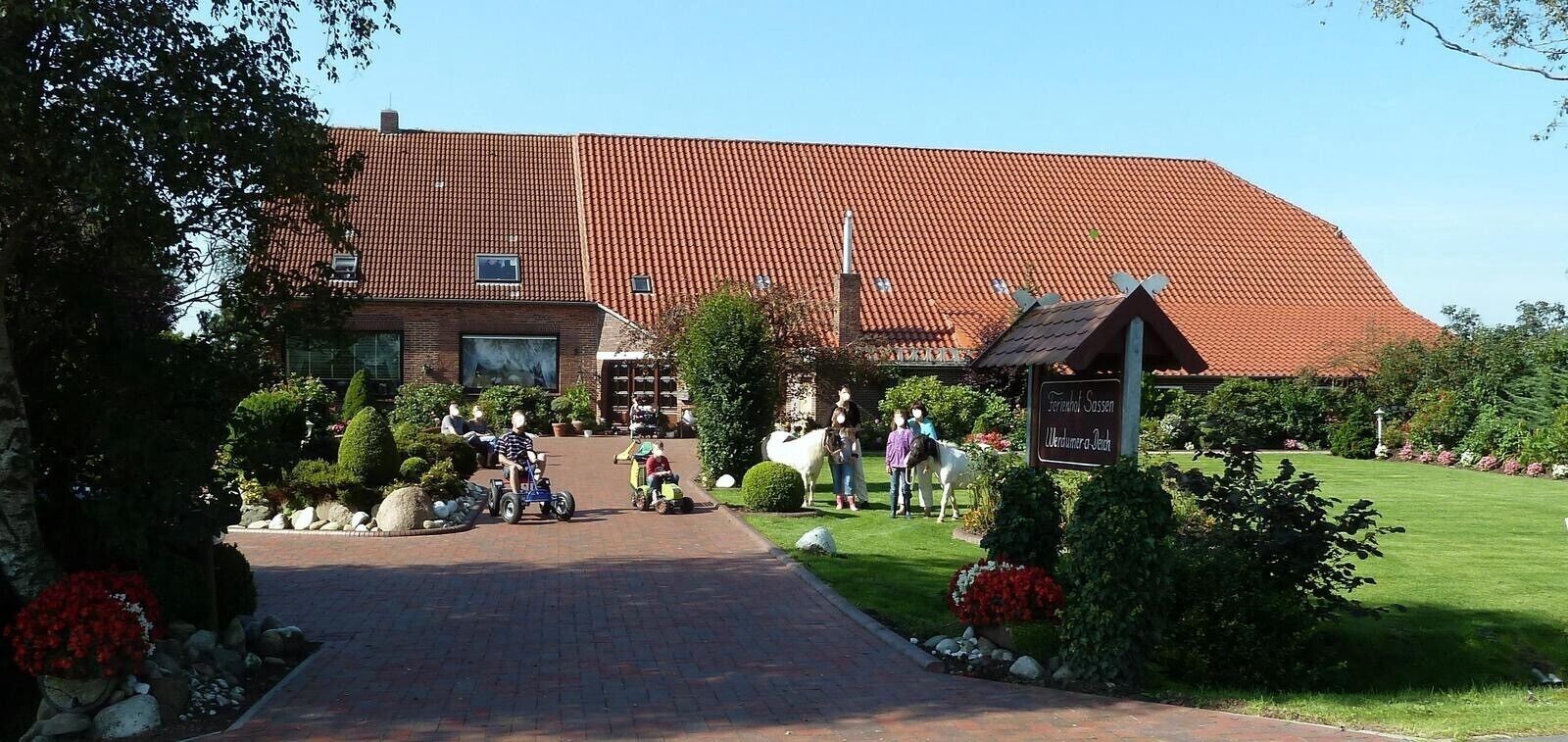 Ein Gebäude mit rotem Ziegeldach, Backstein-Eingang und Schild, das Restaurant und Bar anzeigt.