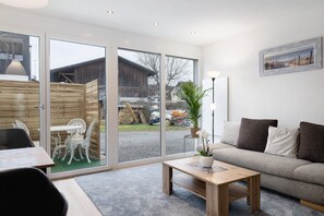 Uma sala de estar moderna com sofá, mesinha de centro e área de jantar com cadeiras e mesa.
