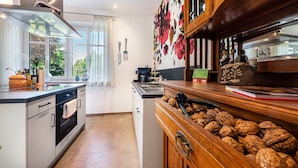 A modern kitchen with a central island, wooden cabinets, and a walnut display. - Apartment Kronsberg with Sauna, Private Garden, Wi-Fi and Air Conditioning (Bösel)