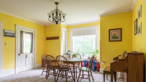 A dining area with a wooden table and chairs, a chandelier, and a piano. - The 2,400 sq. ft. Plymouth Paddock near Road America, 4 bedrooms, 2.5 bathrooms  (Plymouth)