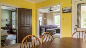 A dining area with a wooden table and chairs, a sofa, and a ceiling fan in a room with yellow walls. - The 2,400 sq. ft. Plymouth Paddock near Road America, 4 bedrooms, 2.5 bathrooms  (Plymouth)