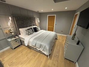 Una camera da letto moderna con un letto, comodini, una cassettiera e una porta.