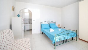 A bedroom with a bed, a desk, a chair, and a wardrobe. - La Conchiglia di Torre Vado with Sea View, Morciano di Leuca, Italy (Morciano di Leuca)