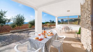 A covered outdoor dining area with a table set for two, chairs, and a view of the landscape. - La Conchiglia di Torre Vado with Sea View, Morciano di Leuca, Italy (Morciano di Leuca)