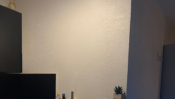 A modern kitchen with a blue under-cabinet lighting, a black countertop, and a small potted plant. - Le Cocoon / Free parking / Wifi (Belfort)