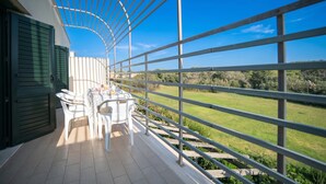 A balcony with a table and chairs, a view of a green landscape, and a metal railing. - Alba Apartment 2 with Pool and Sea n.46, Otranto, Italy (Otranto)