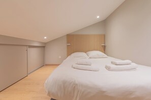 Un dormitorio con una cama, almohadas y cabecera de listones de madera.