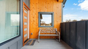 A wooden exterior with a bench and a welcome mat. - Modern Masterpiece in Downtown Tulsa-Sleeps 6 (Tulsa)