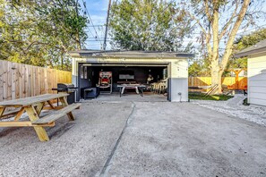 Un garage dans lequel est garé un camion de pompiers, une table de pique-nique à l’extérieur et un espace de détente extérieur abrité.