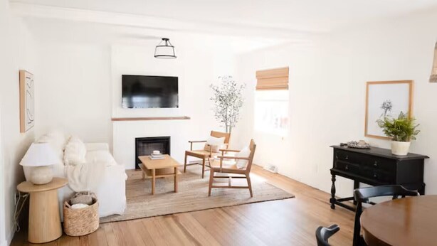 Un salon moderne avec une cheminée, des meubles en bois et un téléviseur à écran plat.