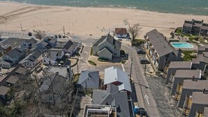 Een woongebied aan de kust met huizen, een strand en een zwembad.
