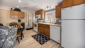 Una cocina compacta con armarios de madera, microondas, horno y refrigerador.