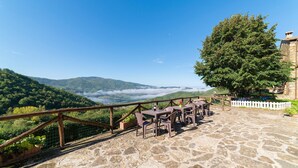A stone patio with outdoor seating, overlooking a mountainous landscape with a clear sky. - Gorgeous home in Dicomano with WiFi (Dicomano)