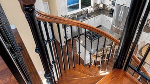 A modern kitchen with white cabinets, a stainless steel refrigerator, and a granite countertop. - Capitola Village Home - Free Parking & Sleeps 8! (Capitola)