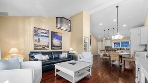 A spacious living area with a sofa, coffee table, and artwork on the wall. - Capitola Village Home - Free Parking & Sleeps 8! (Capitola)