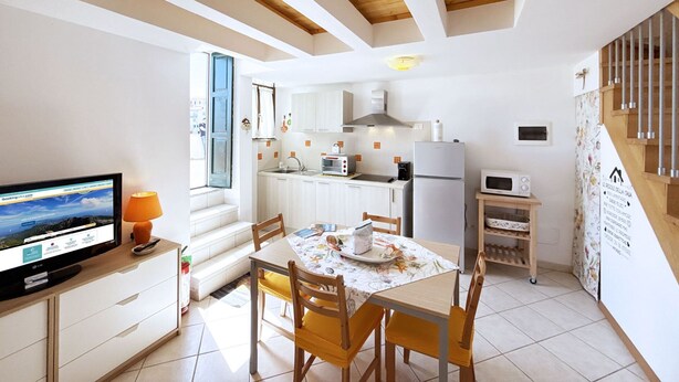 A compact kitchen with white cabinets, a built-in oven, and a microwave.