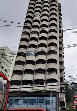 Un immeuble de grande hauteur doté de nombreux balcons et d’une entrée en verre.