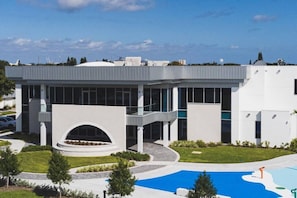 Un edificio moderno con un patio central, ventanas grandes y una piscina.