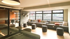 A modern interior with seating areas, large windows, and a visible 'SALA 02' sign. - R Lindo departamento 1BR en Miraflores (Lima)