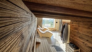 A wooden interior with a sloped ceiling, a built-in bench, and a view of the outdoors. - Holiday Home in Roprachtice With Sauna & Jacuzzi (Roprachtice)