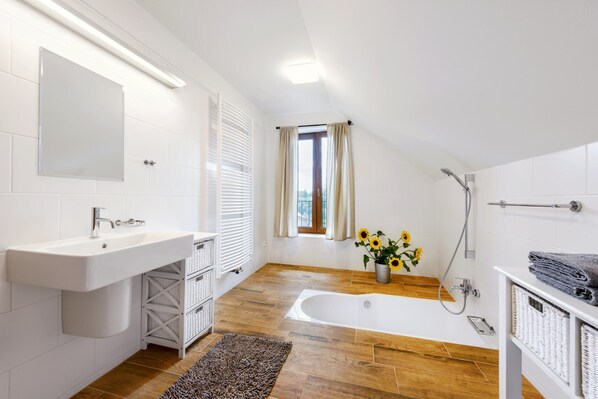 A modern bathroom with a white sink, a bathtub, and a shower. - Villa in Varvazov With Garden Retreat (Varvažov)