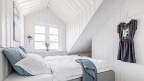 A bedroom with a loft bed, a window, a plant, and a hanging dress. - 5 Star Holiday Home in Hjorring (Hjørring)