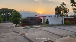 Una strada residenziale con file di case, cielo sereno e tramonto.