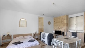 Un dormitorio con cama, mesitas de noche, un escritorio y una silla.