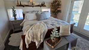A bedroom with a bed, bedside tables, a nightstand, a dresser, a window with curtains, and a small plant. - The Jefferson Guest House, Spacious, Special Views (Litchfield)