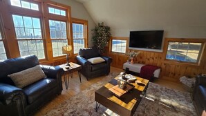 A cozy living room with a fireplace, a large window, and a television. - The Jefferson Guest House, Spacious, Special Views (Litchfield)
