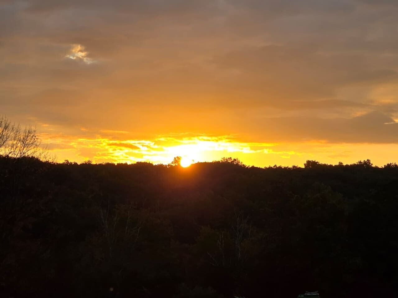 A sunset over a forested landscape.