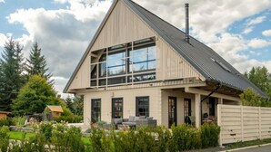 A modern house with a sloped roof, large windows, and a chimney. - Villa in Abertamy Near Klinovec Ski Resort (Abertamy)