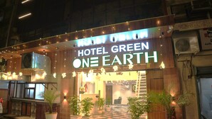 A hotel named "Hotel Green One Earth" with a modern design, potted plants, and a check-in counter. - Hotel Green One Earth (Amritsar)