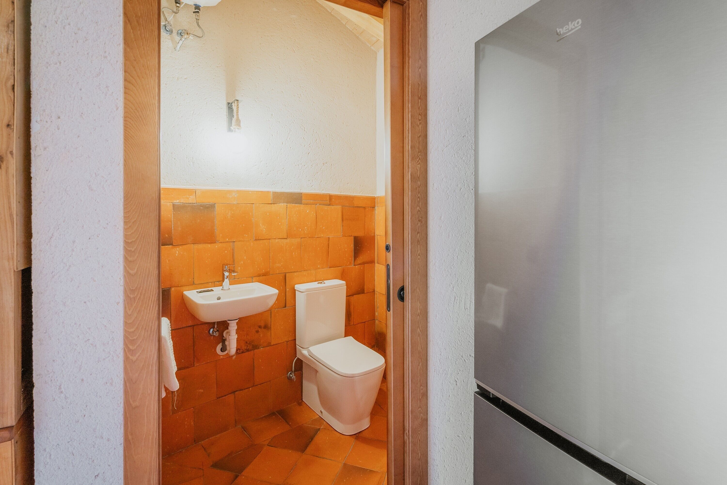 Een badkamer met een wastafel, toilet en spiegel.