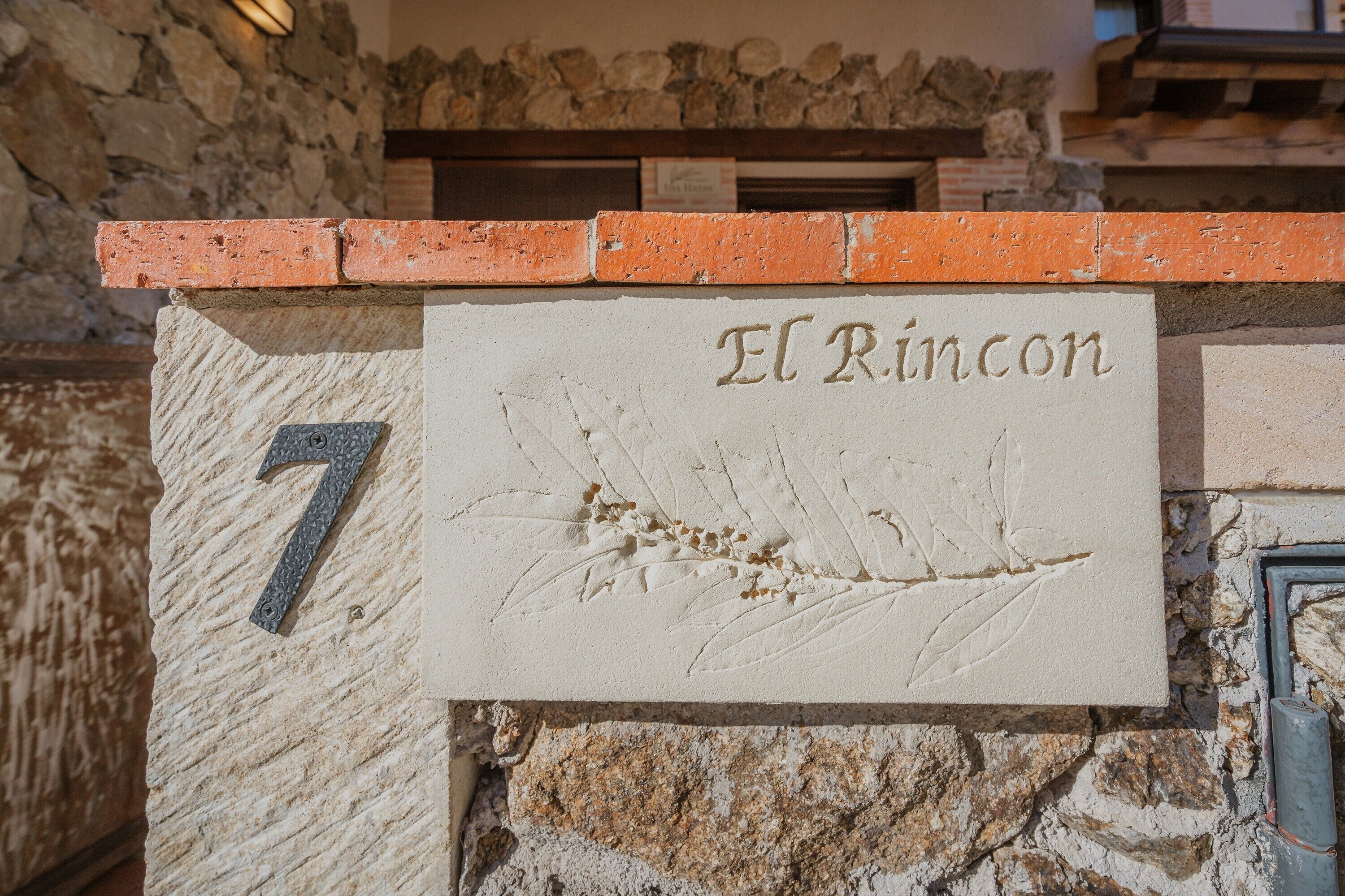 A stone wall with a sign reading 'El Rincon' and the number '7' on it.