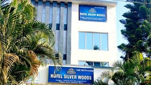 Ένα ξενοδοχείο με την ονομασία HOTEL SILVER WOODS, το οποίο διαθέτει μια επιγραφή που αναγράφει το όνομα και τον αριθμό τηλεφώνου του.
