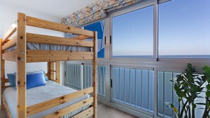 Habitación con literas, una ventana grande y vista al mar.
