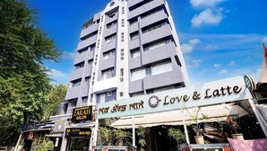 A multi-story building with a sign for 'Love & Latte' on the ground floor. - Vibes INN (Mumbai)