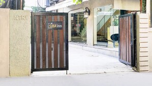 A gated entrance to a property with a sign reading "SJB Inn". - Vibes INN (Mumbai)