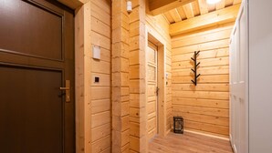 A wooden interior hallway with a door, a light fixture, and a small table. - Tranquil Villa in Velke Karlovice (Velké Karlovice)