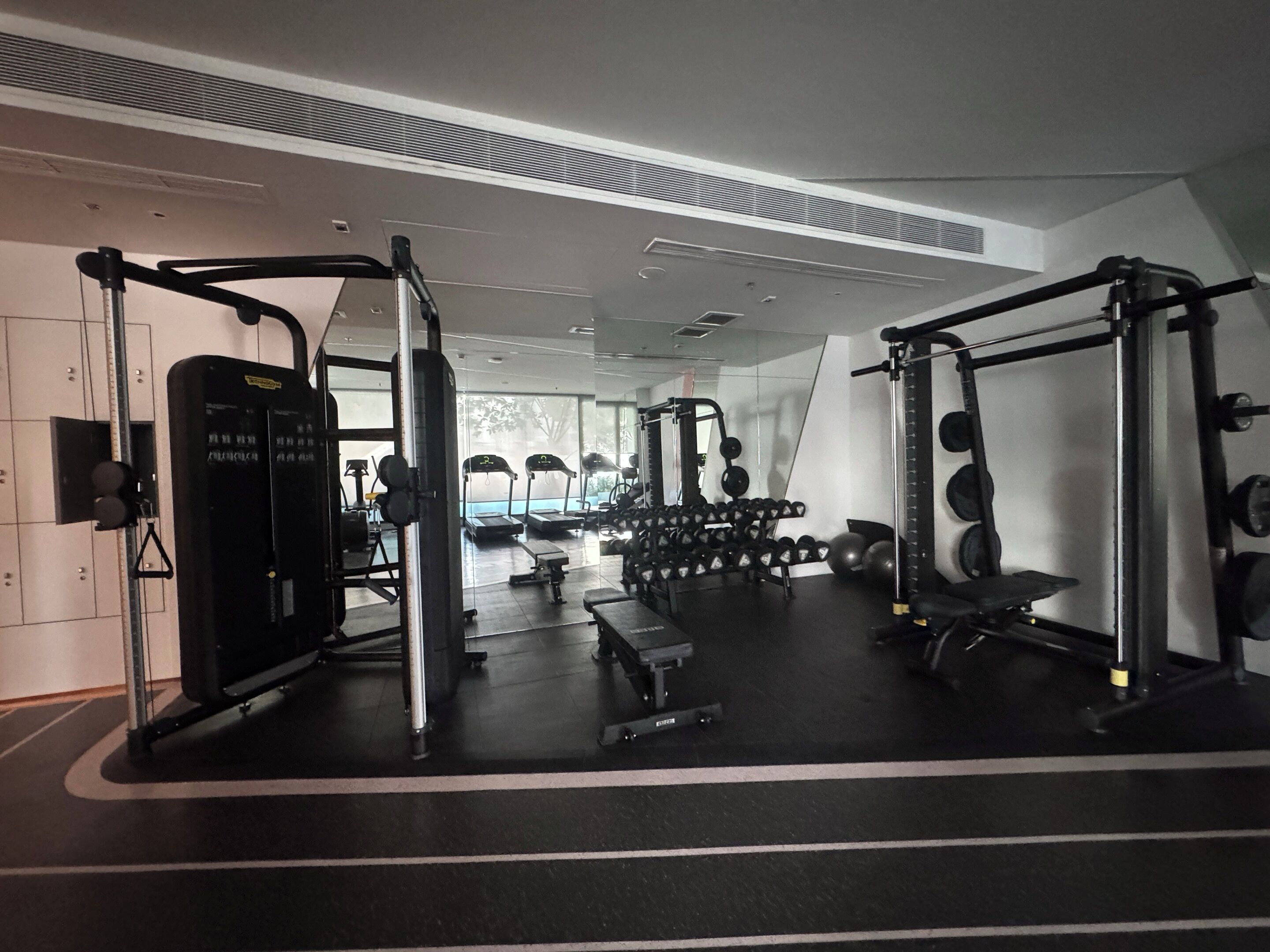 Een sportschool met gewichthefapparatuur, loopbanden en halterset.