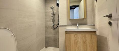 Un baño moderno con inodoro, ducha y tocador.
