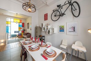 Enjoy meals in this stylish dining area with a long table and adjacent living space.