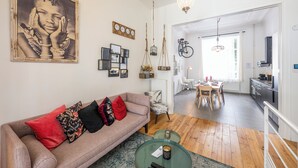 A modern living room with a sofa, a dining table, and a kitchen area. - Stylish 3 Bd 3 Bath Duplex In Brussels (Brussels)