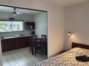 Cozy retreat with a bed, dining area, and microwave, perfect for a comfortable stay.