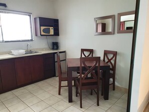 Enjoy meals at the dining table with four chairs, accompanied by a microwave and coffee maker.